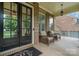 Cozy front porch featuring stylish seating, black double-doors, and brick accents at 16109 Reynolds Dr, Indian Land, SC 29707