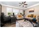 Comfortable living room with large windows, plush seating, and a ceiling fan at 16109 Reynolds Dr, Indian Land, SC 29707