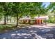 Inviting exterior of a brick home with lush trees and a paved driveway leading to a covered carport at 175 Triplett Rd, Cleveland, NC 27013