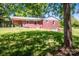 Rear exterior of a brick home featuring a covered patio and a sloped yard at 175 Triplett Rd, Cleveland, NC 27013