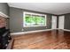 Spacious living room boasts hardwood floors, a brick fireplace, and a large window overlooking the yard at 175 Triplett Rd, Cleveland, NC 27013