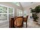 Cozy dining area with a glass topped bar, two barstools, and large windows for natural light at 18846 Cloverstone Cir, Cornelius, NC 28031