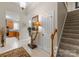 Inviting hallway with stairs, doorway, and a stylish table lamp at 18846 Cloverstone Cir, Cornelius, NC 28031