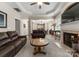 Open-concept living room features a fireplace, ceiling fan, and seamless access to the dining area at 18846 Cloverstone Cir, Cornelius, NC 28031