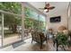 Relaxing sunroom with walls of windows offering views to the outside, comfortable seating, and a ceiling fan at 18846 Cloverstone Cir, Cornelius, NC 28031