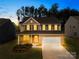Charming two-story home with brick and tan siding, a well-manicured lawn, and inviting curb appeal at twilight at 191 Tackle Box Dr, Troutman, NC 28166