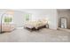 Light-filled primary bedroom with a king bed, bench seat, and neutral decor at 191 Tackle Box Dr, Troutman, NC 28166