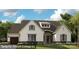 Inviting Santa Fe-French cottage featuring a stone-accented entrance, attached garage, and manicured lawn at 19329 Youngblood W Rd # 4, Charlotte, NC 28278