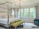 Elegant primary bedroom features a metal canopy bed, soft lighting, and large windows with nature views at 19329 Youngblood W Rd # 4, Charlotte, NC 28278