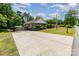 View of the single-story home featuring a long driveway with manicured lawn and shrubbery at 201 Easy St, Concord, NC 28027