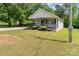 Charming home featuring a covered front porch with grey railings and a vibrant red door at 201 Easy St, Concord, NC 28027