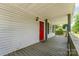 View of the front porch featuring a gray deck and a red front door at 201 Easy St, Concord, NC 28027