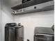 Modern laundry room with gray front-loading washer and dryer units and upper shelves at 201 Easy St, Concord, NC 28027
