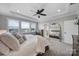 Bright main bedroom featuring an ensuite bath and a large mirror reflecting the bed and ceiling fan at 2025 Masons Bend Dr, Fort Mill, SC 29708
