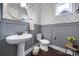 Well-lit powder room featuring stylish wallpaper, gray wainscoting, and a classic pedestal sink at 2025 Masons Bend Dr, Fort Mill, SC 29708