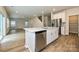 Open kitchen design with stainless steel appliances, white cabinetry, and island, leading to a living space at 2149 Sunflower Cir, Newton, NC 28658