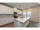 Modern kitchen featuring white cabinets, stainless steel appliances, an island, and wood-look flooring at 2149 Sunflower Cir, Newton, NC 28658