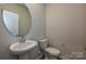 Elegant powder room featuring a modern sink, round mirror, and neutral decor at 2149 Sunflower Cir, Newton, NC 28658