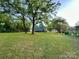 Large, grassy backyard surrounded by trees, with the home in the background at 222 Brevard St, Statesville, NC 28677