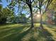Expansive backyard with mature trees and a glimpse of the home with back deck at 222 Brevard St, Statesville, NC 28677