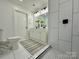 White tiled bathroom featuring double vanity, tiled shower and updated fixtures at 222 Brevard St, Statesville, NC 28677
