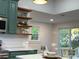 Bright eat-in kitchen features stainless appliances and view into the bright dining space with a sliding glass door at 222 Brevard St, Statesville, NC 28677