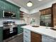 Bright eat-in kitchen features stainless appliances, island with bar seating, and striking emerald green cabinets at 222 Brevard St, Statesville, NC 28677