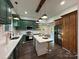 Bright eat-in kitchen features stainless appliances, island with bar seating, and striking emerald green cabinets at 222 Brevard St, Statesville, NC 28677