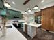 Bright eat-in kitchen features stainless appliances, island with bar seating, and striking emerald green cabinets at 222 Brevard St, Statesville, NC 28677