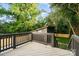 Modern back deck with gray wood and railing overlooks a lush green yard and wooded area at 2224 Highland St, Charlotte, NC 28208