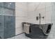 Sleek bathroom featuring a unique black tub, mosaic tile floor, and stylish wall tiles at 2224 Highland St, Charlotte, NC 28208