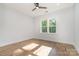 Bright bedroom featuring hardwood floors, a modern ceiling fan, and a window with a view of lush greenery at 2224 Highland St, Charlotte, NC 28208