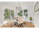 Bright dining area featuring a modern light fixture, glass table, and sliding door access to the deck at 2224 Highland St, Charlotte, NC 28208