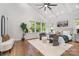 Spacious main bedroom with vaulted ceilings, large windows, stylish seating area, and hardwood floors at 2224 Highland St, Charlotte, NC 28208