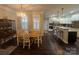 Open-concept dining area with hardwood floors and stylish light fixture, adjacent to kitchen at 2279 Eversham Nw Dr, Concord, NC 28027
