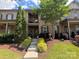 Brick townhome with well-manicured lawn, front porch, balcony, and decorative shrubbery at 2279 Eversham Nw Dr, Concord, NC 28027