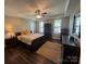 Comfortable main bedroom with tray ceiling, ceiling fan, a large window, and hardwood floors at 2279 Eversham Nw Dr, Concord, NC 28027