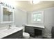 The bathroom features a grey vanity, a white countertop, a shower and a bright window at 2306 W C St, Kannapolis, NC 28081