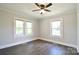 This bedroom features wood flooring, natural light, a modern ceiling fan, and neutral color palette at 2306 W C St, Kannapolis, NC 28081