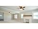 Bright living room with white painted brick fireplace, large windows, and ceiling fans at 2306 W C St, Kannapolis, NC 28081