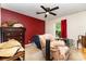 Bedroom with red accent wall, ceiling fan, and comfortable seating area at 2718 Ridgewood Ln, Rock Hill, SC 29730