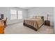 Well-lit bedroom featuring carpet floors, white walls, and bright windows at 312 Farm Springs Dr, Mount Holly, NC 28120