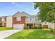 Charming two-story home with a brick facade, manicured lawn, and attached two-car garage at 312 Farm Springs Dr, Mount Holly, NC 28120