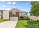 Charming two-story home with a brick facade, manicured lawn, and attached two-car garage at 312 Farm Springs Dr, Mount Holly, NC 28120
