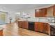 Well-lit kitchen featuring granite countertops, wood cabinets, and black appliances at 312 Farm Springs Dr, Mount Holly, NC 28120