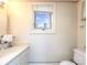 Powder room with white sink, white toilet, and a bright window at 321 W Bank St, Salisbury, NC 28144