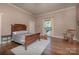 Bedroom featuring a wood bed frame, hardwood floors, a rug, and a window with natural light at 321 W Bank St, Salisbury, NC 28144