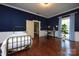 Bedroom featuring dark blue walls, wood floors, a desk, and a large window at 321 W Bank St, Salisbury, NC 28144