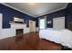 Bedroom with navy walls, hardwood floors, a fireplace, and bright white trim at 321 W Bank St, Salisbury, NC 28144