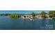 Waterfront property featuring well-manicured lawn, private dock, boat lift, and panoramic lake views at 3386 Governors Island Dr, Denver, NC 28037